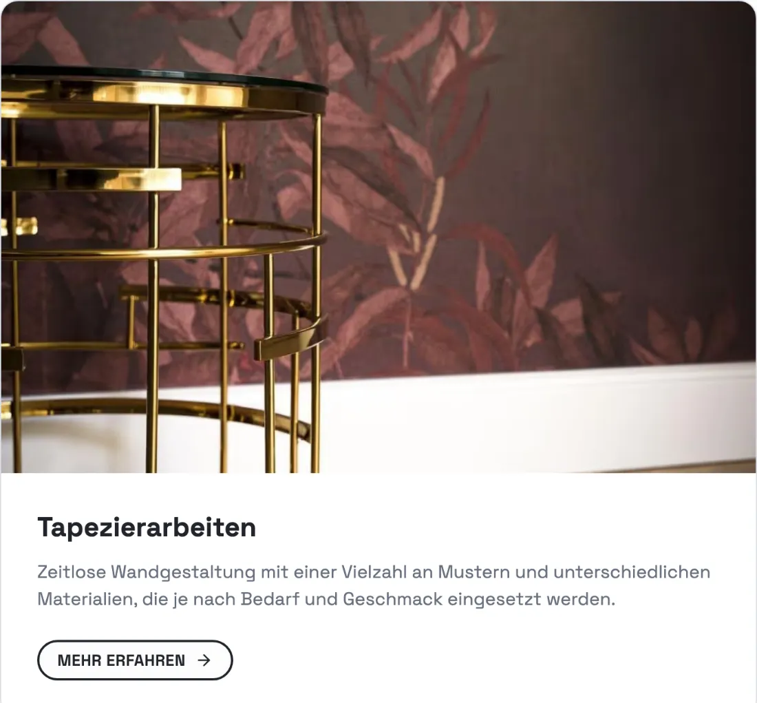 Ausschnitt der Website von Malermeister Heußer, Berlin: Tapete im realen Raum mit Sockelleistenabschluss — wer plant, sieht die Wirkung großer Muster und die saubere Kante.