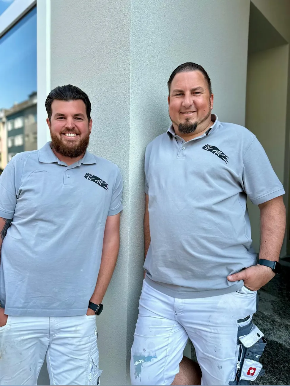 Ausschnitt der Website von Kaiser & Maaßen Maler- & Lackiermeister GbR, Mönchengladbach: Zwei Mitarbeitende im Arbeitsoutfit, deutlich erkennbar — der Besucher weiß, wer kommt, nicht nur ein Firmenname.